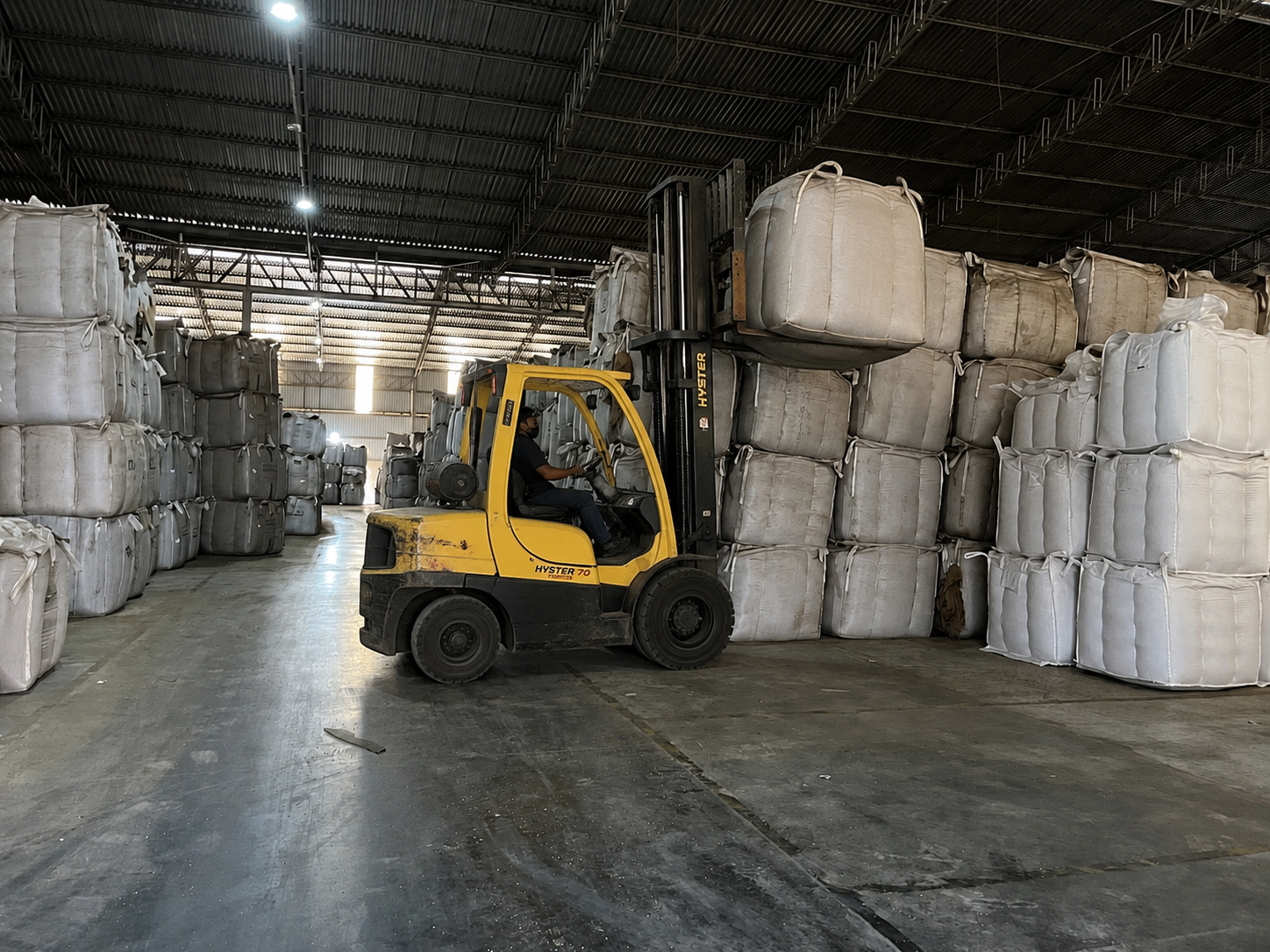 Empilhadeira movimentando big bags no galpão da Sacaria Oeste